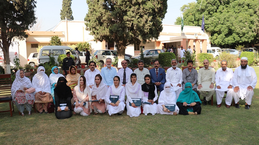 Top position holders of B.A/ B.Sc annual examinations along with their parents pose for a group photo with the dignitaries of the University of Peshawar.